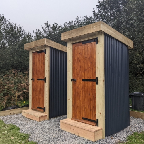 Two matching compost toilets side by side