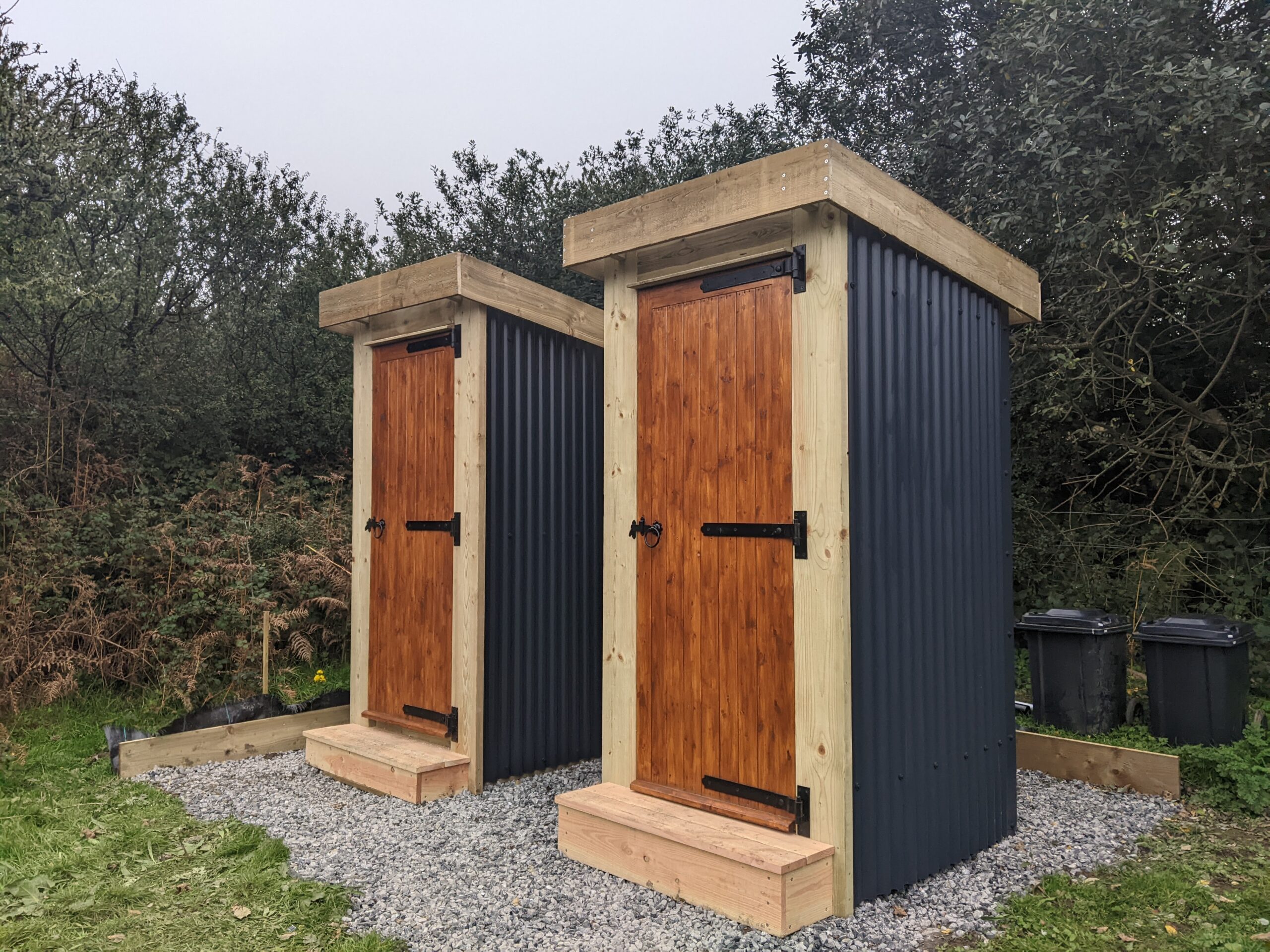 Two matching compost toilets side by side