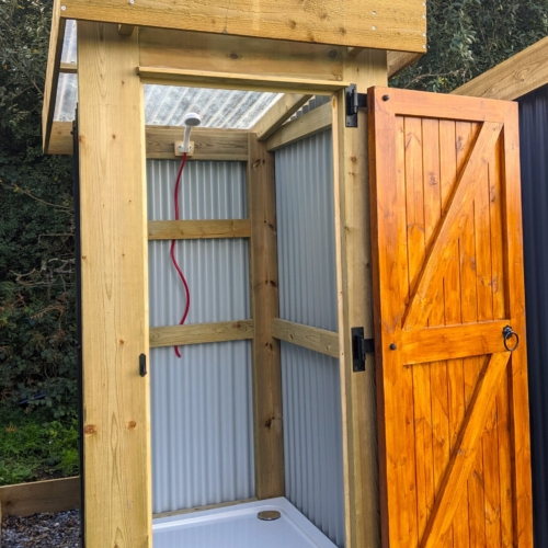 Corrugated finish single depth off grid shower unit with shower tray and stained door